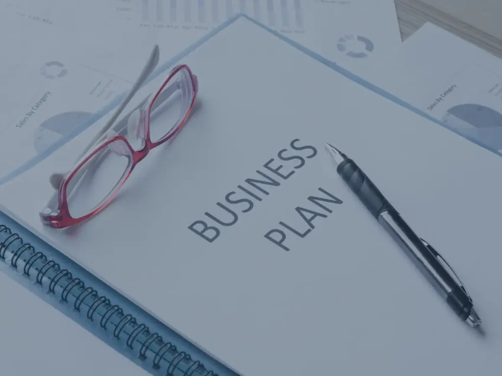 Businessplan als Finanzierungsunterlage mit Brille und Füller auf Auswertungen